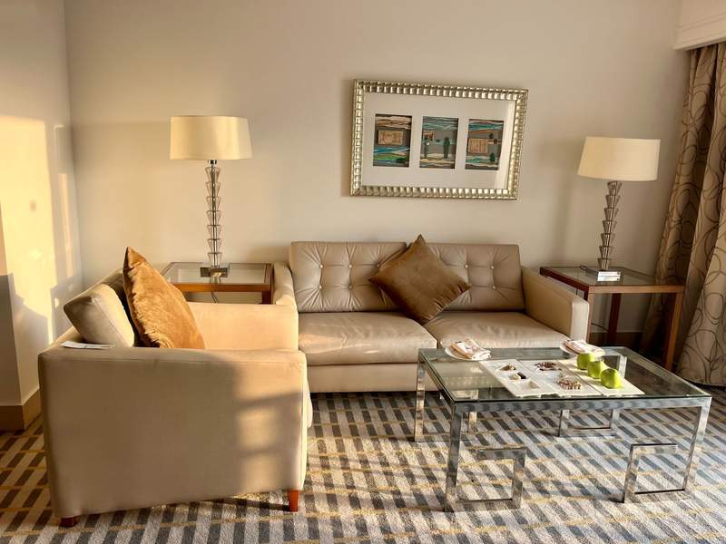 The modern comfortable interior of a hotel room featuring a large window that frames a direct view of the Pyramids of Giza outside.