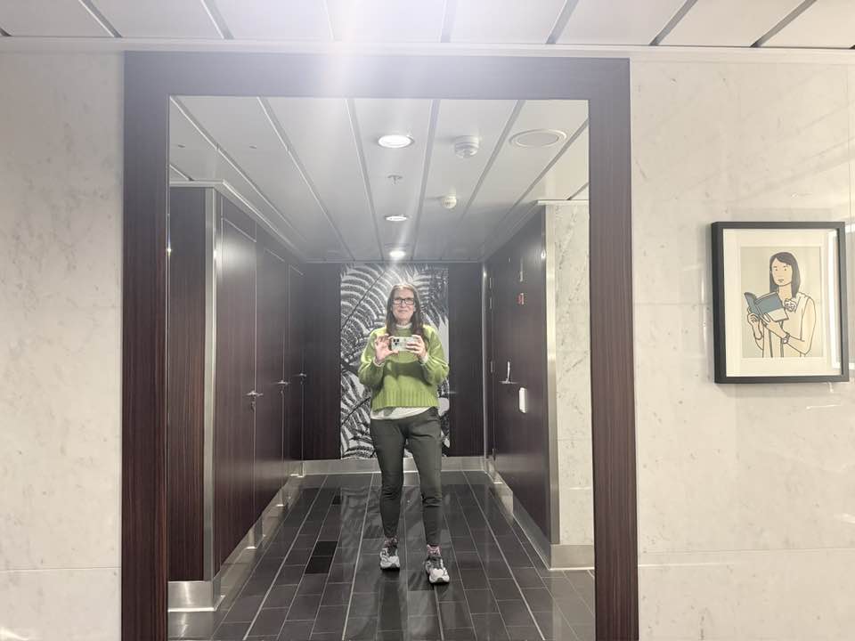 Woman taking a selfie in front of big mirror on board the Celebrity Solstice in Alaska