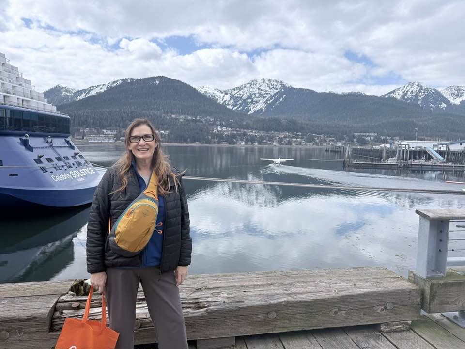 Woman in front of the Celebrity Solstice in Alaska in the port of Juneau