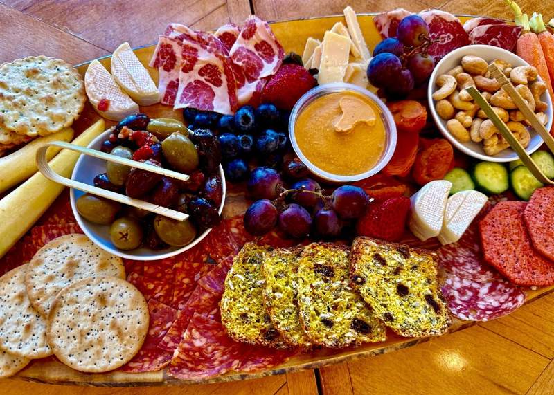 Bite sized foods with an array of colors fill a charcuterie board.