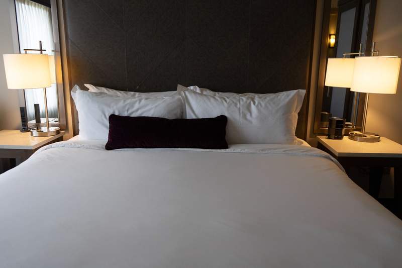 Modern luxury guest room at Saint John's Resort in Plymouth Michigan featuring a plush bed and neutral colors