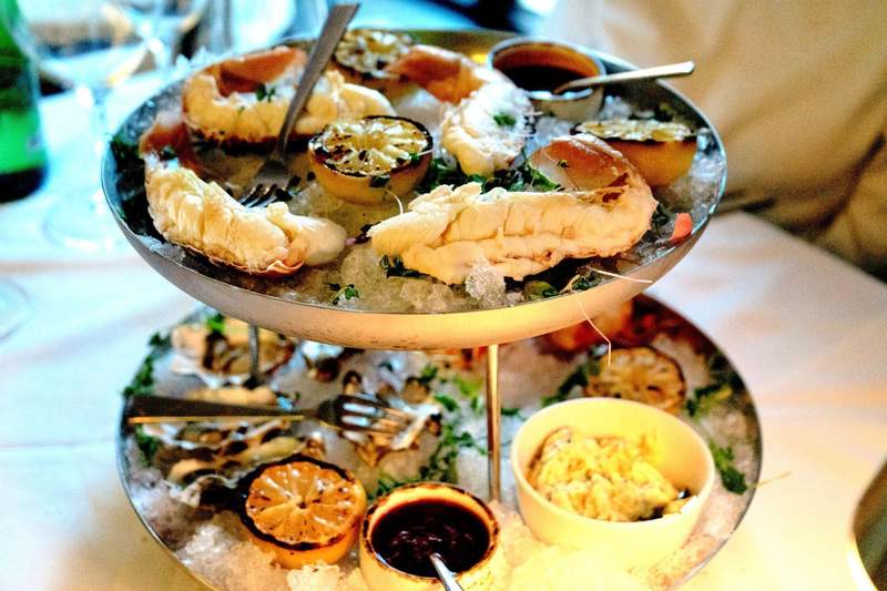 A multi-tier gourmet seafood tower featuring lobster tail and clams at Five Steakhouse