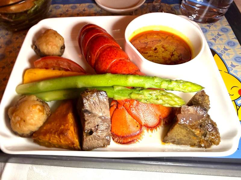 Airline meal with steak, lobster, asparagus and potatoes.