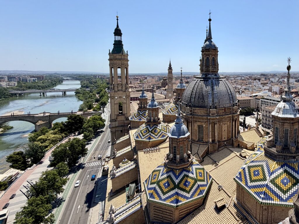 Colorful tiled bases of cathedral spires at Our Lady of the Pillar in Zaragoza Spain with the River Ebro in the background