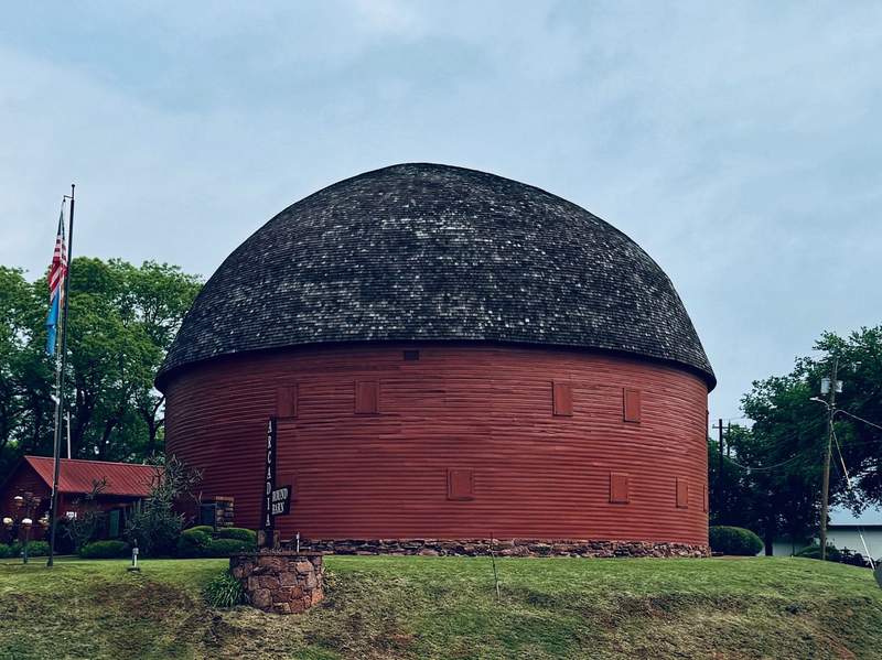 Round barn with red walls in a grassy field