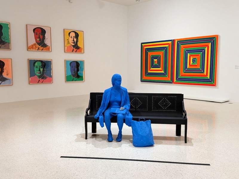 Modern art gallery interior at the NSU Art Museum featuring contemporary pop art photography and a blue lady sculpture.