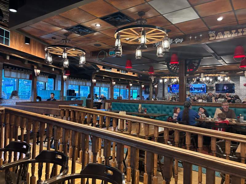 An intimate dining room setting inside a cozy Gatlinburg restaurant, featuring warm wood accents, soft lighting, and tables set for couples looking for a relaxed dinner date.