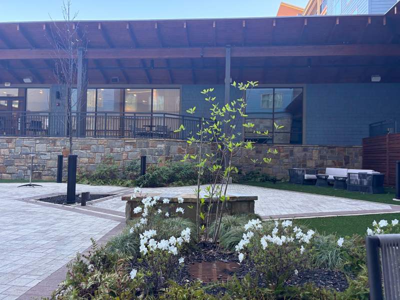 Outdoor common area at the Embassy Suites by Hilton Gatlinburg Resort. Features comfortable woven lounge seating a fire pit and stone accents.