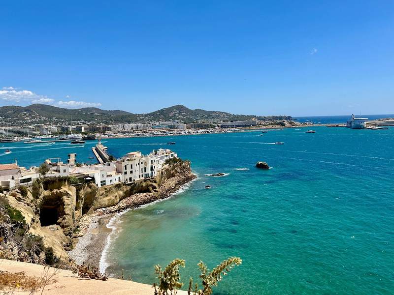 Coastal View looking down at city, harbor and turquoise blue water.
