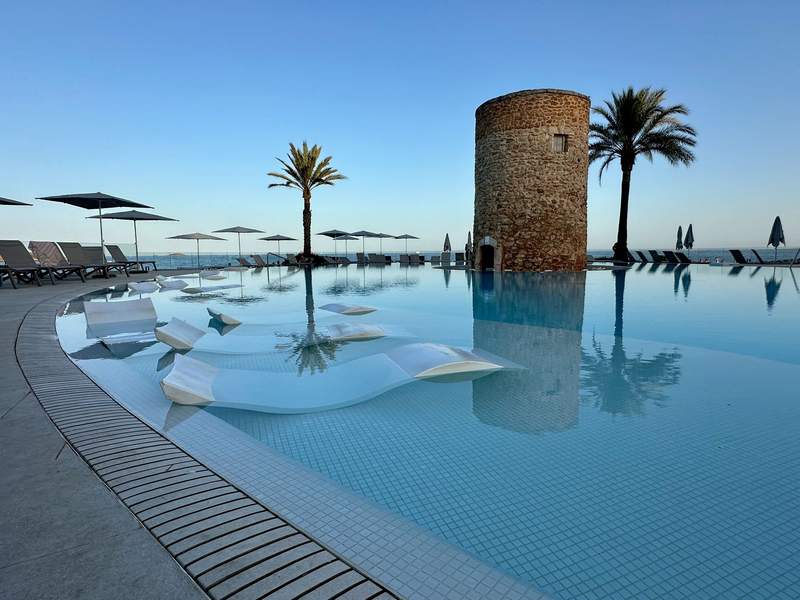 Sunset on the pool and stone tower of Hotel Torre del Mar