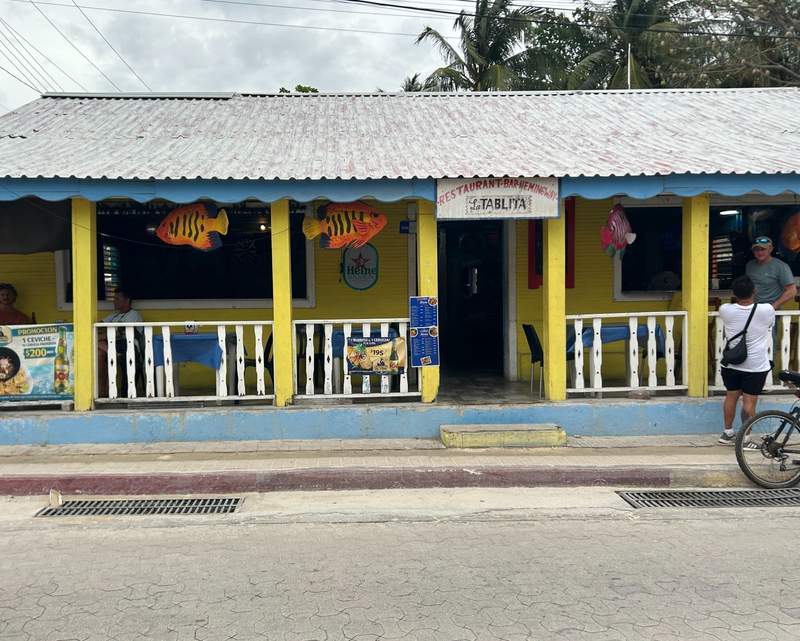 La Tablita restaurant on Isla Mujeres, a bright yellow-and-blue Caribbean-style building decorated with colorful fish, where local legend says Ernest Hemingway stopped before traveling to Cuba.