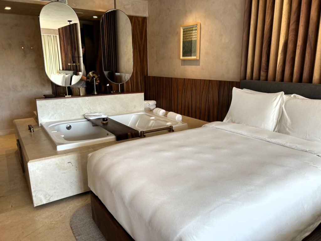Suite at Almare, a Luxury Collection Resort, Isla Mujeres, featuring a king-size bed beside a large in-room soaking tub