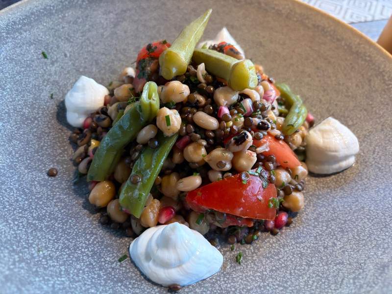 A fresh salad with tomatoes, garbanzo beans, farrow, okra, sea kelp and Cretan cheese.