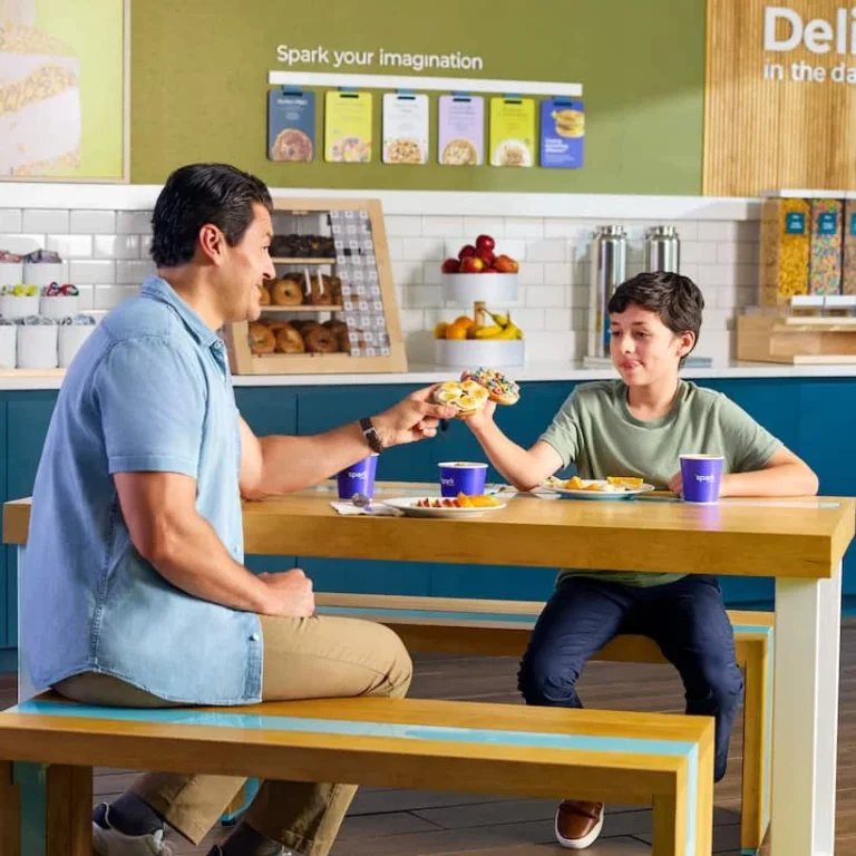 man and boy eating bagels at a Spark by Hilton hotel