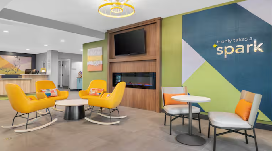 orange rockers and a table and chairs in the lobby of the Spark by Hilton Colorado Springs hotel