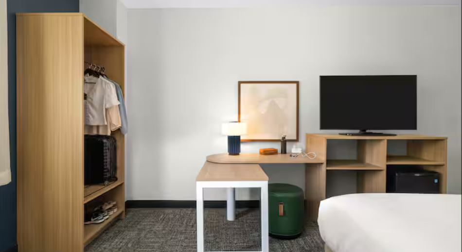 The closet and desk area of a Spark by Hilton hotel room