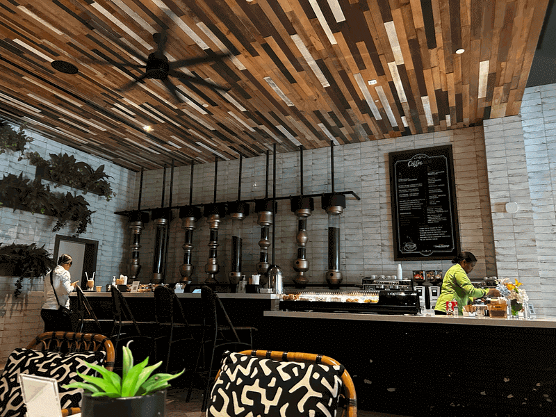 A refreshing glass of iced coffee resting on a table at a modern resort café with a relaxed outdoor atmosphere.