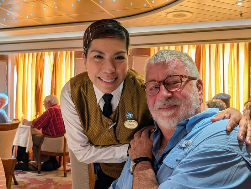 A female Princess cruise waiter poses with a passenger