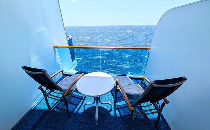 A Princess cruise ship balcony with two chairs and a small table