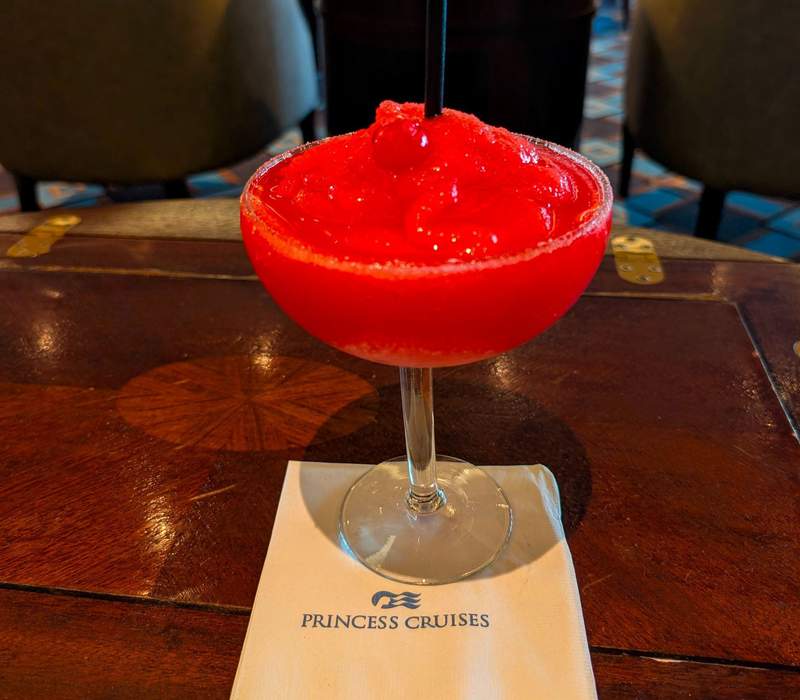 A red drink and Princess Cruises napkin