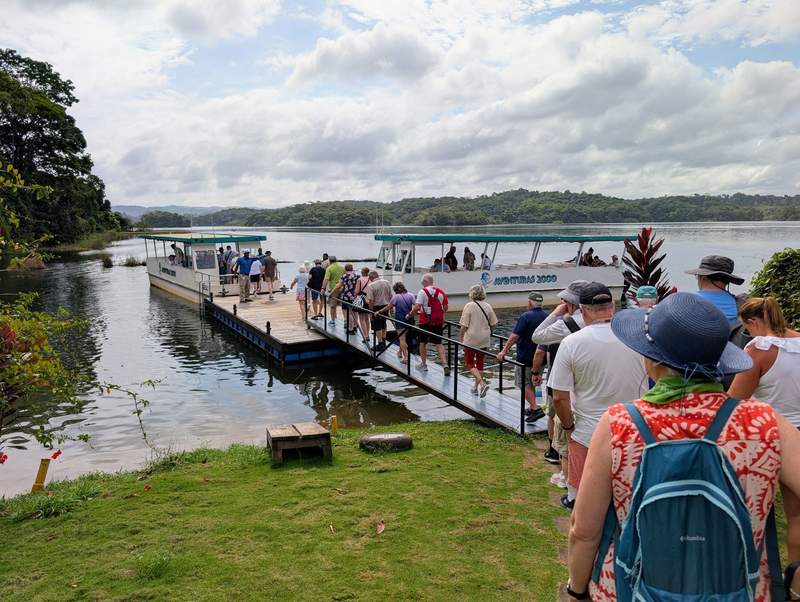 A line of people waiting to get on a small boat