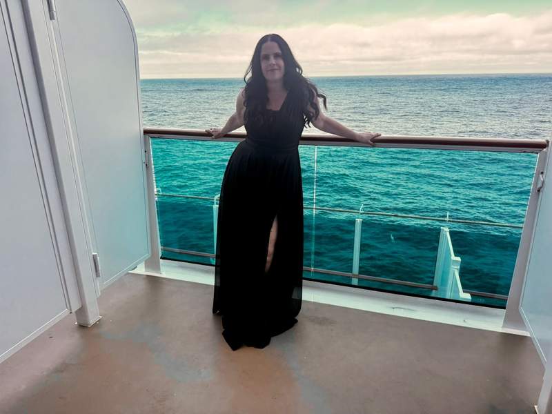 Formal night aboard Star Princess, standing on our deluxe balcony in an elegant gown.