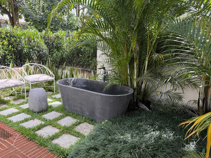Luxury outdoor soaking tub surrounded by lush tropical gardens at Villa Bokeh hotel in Guatemala