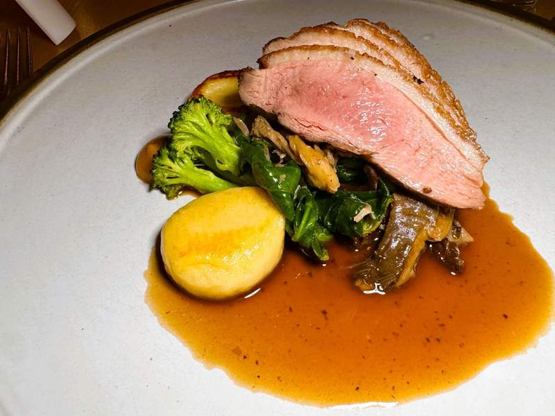 Sliced roasted duck served atop brocolini, potatoes and greens with an au jus.