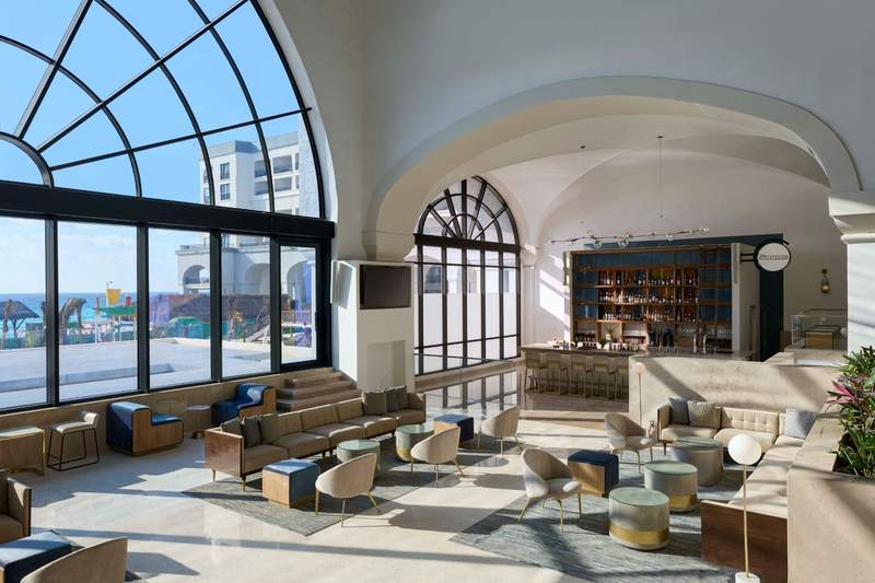 Hotel lobby with high ceilings seating areas and tropical decor
