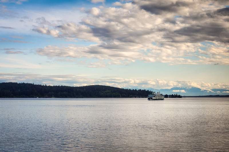 A large white passenger and vehicle ferry cruising across open water