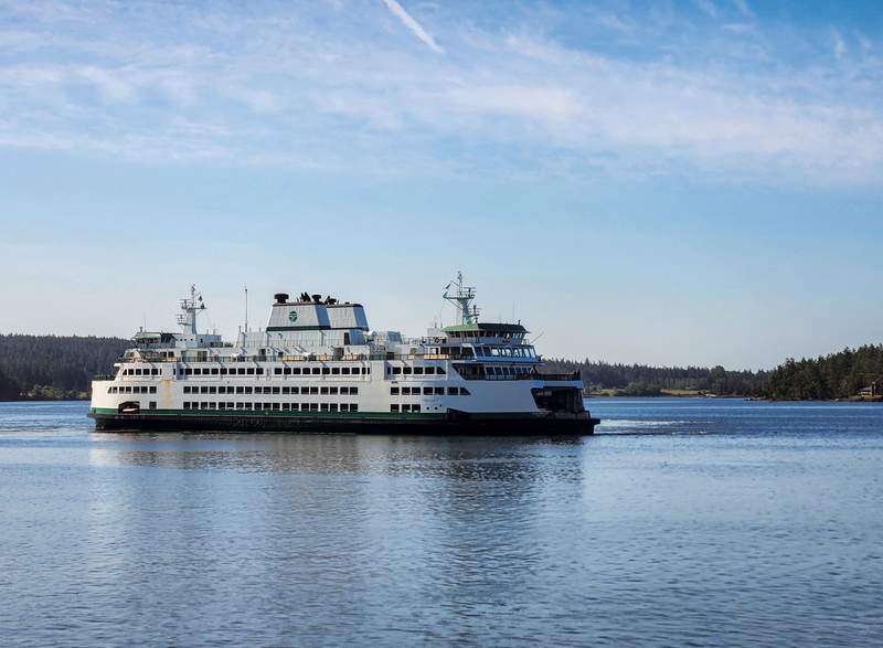 A ferry on the water near an island