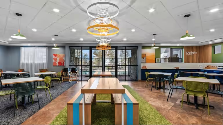 multi-colored lobby with dining tables and views of a bright sunny day