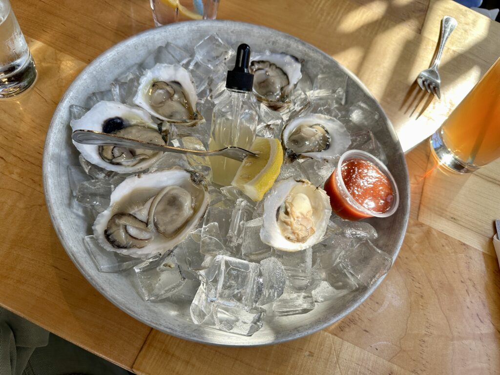 Plate of raw oysters on ice with cocktail sauce at a Nantucket restaurant in the fall