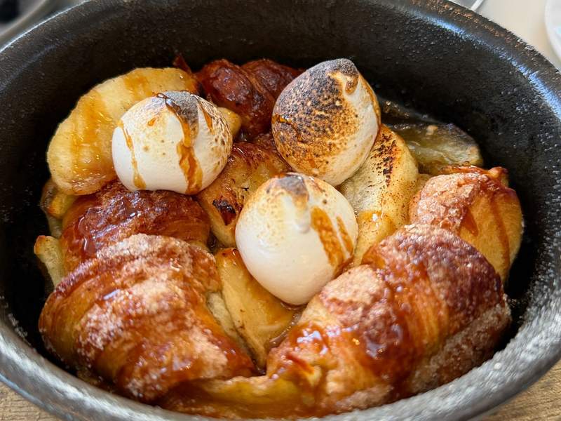 close up of ooey gooey, a brunch item at Arc. Bread chunks with caramel drizzle and roasted marshmallow dots.