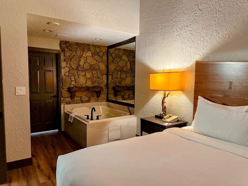 Hotel suite with soaking tub beside the bed