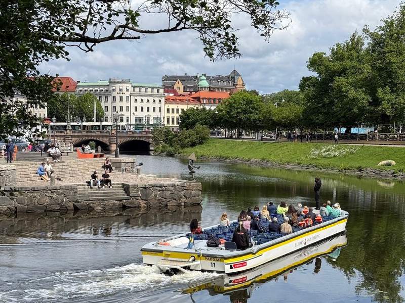 Gothenburg’s canal with tourist boat, bridge and city vistas. 