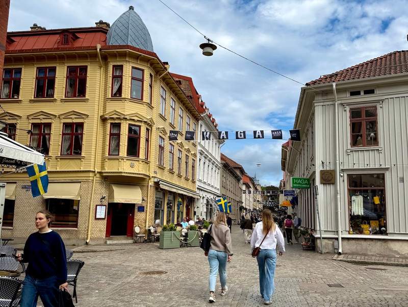 People walking toward Gothenburg’s Haga neighborhood, lined with traditional wooden buildings.