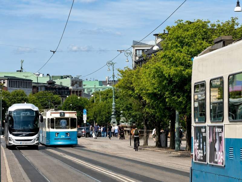 Blue-and-white trams and bus down a street in Gothenburg 
