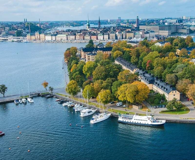 Hotel Skeppsholmen’s historic buildings on Skeppsholmen Island, surrounded by water with Stockholm’s Old Town in the distance.
