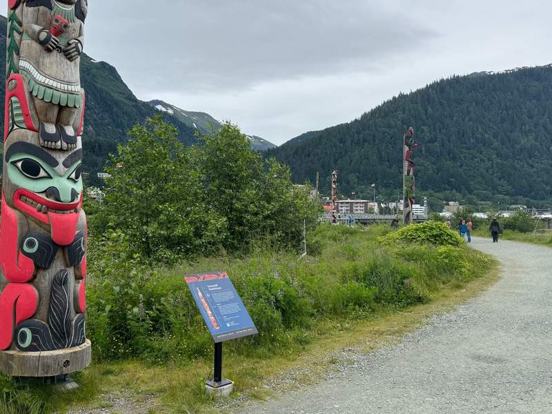 Hand-carved Alaska Native totem pole along the Kootéeyaa Deiyí Totem Pole Trail on the Juneau Seawalk overlooking the waterfront.