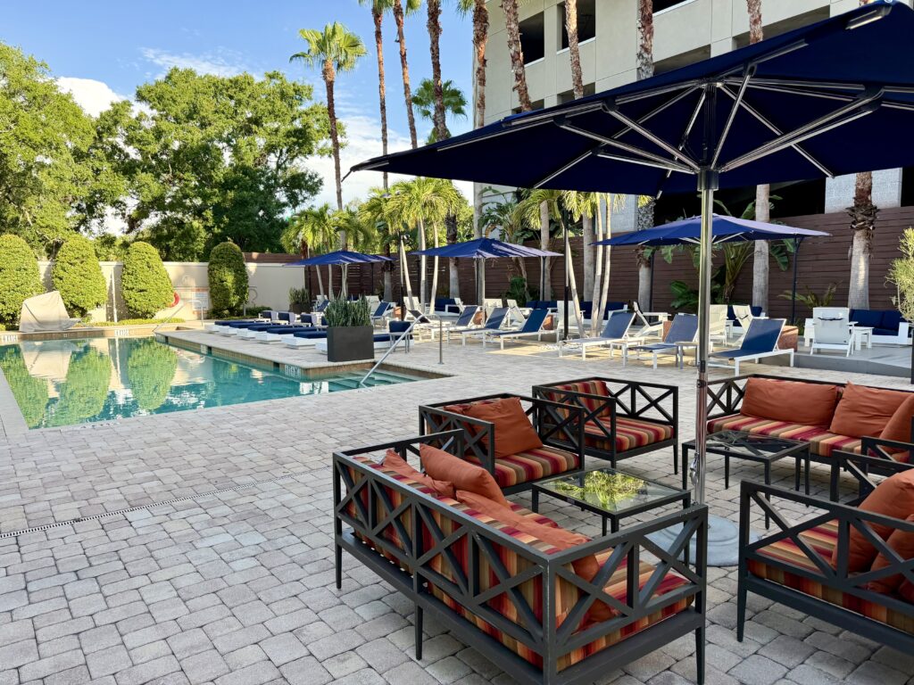 Pool with navy lounge chairs and an orange seating area at the Epicurean Hotel, Autograph Collection in Tampa