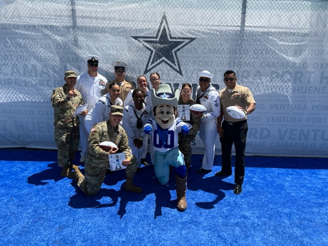 Rowdy, the Dallas Cowboys mascot with military football fans from all services posing at the Cowboys Training Camp