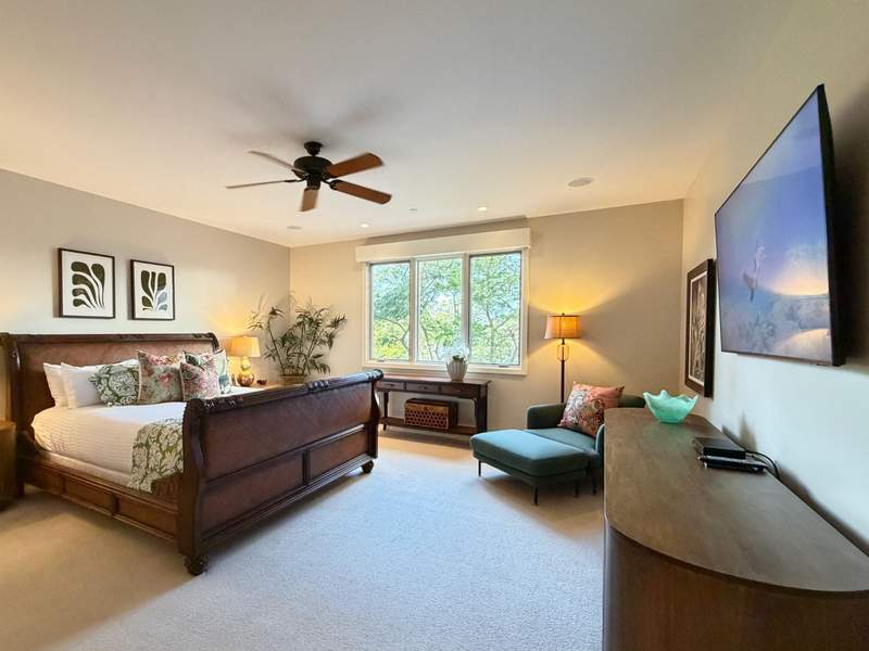 Spacious bedroom with king bed and sitting area overlooking green trees at Wailea Beach Villas