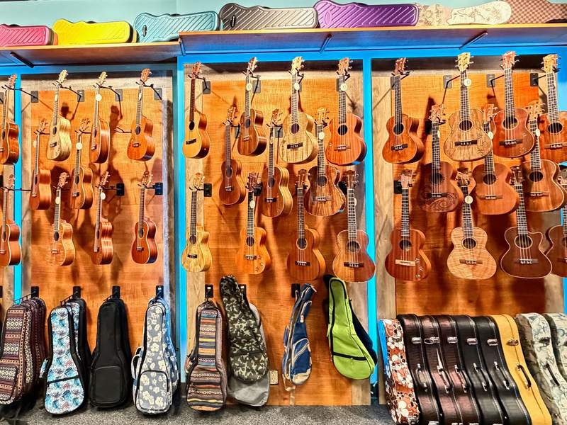 Wall of Hawaiian ukuleles and colorful ukelele bags and cases for sale at Mele Ukelele at The Shops in Wailea.