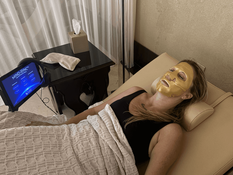 A woman lies in a recovery bed with a gold face mask at the Waldorf Astoria Recovery Lounge in New Orleans.