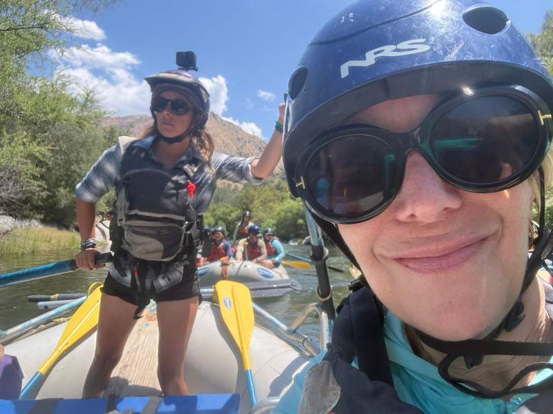 Author smiling with river guide in background.