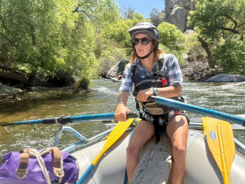 Woman guiding a raft along the Kern River.
