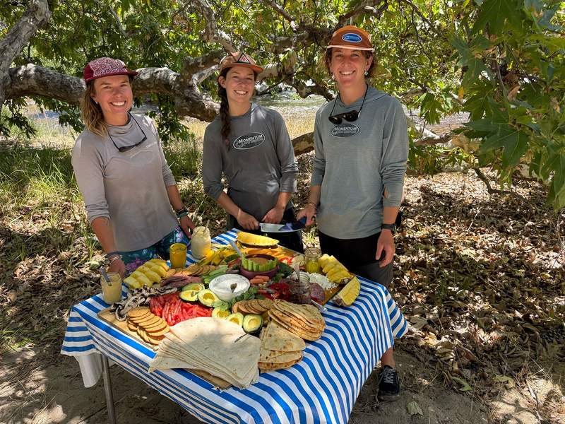 Three women attending to a snack table.