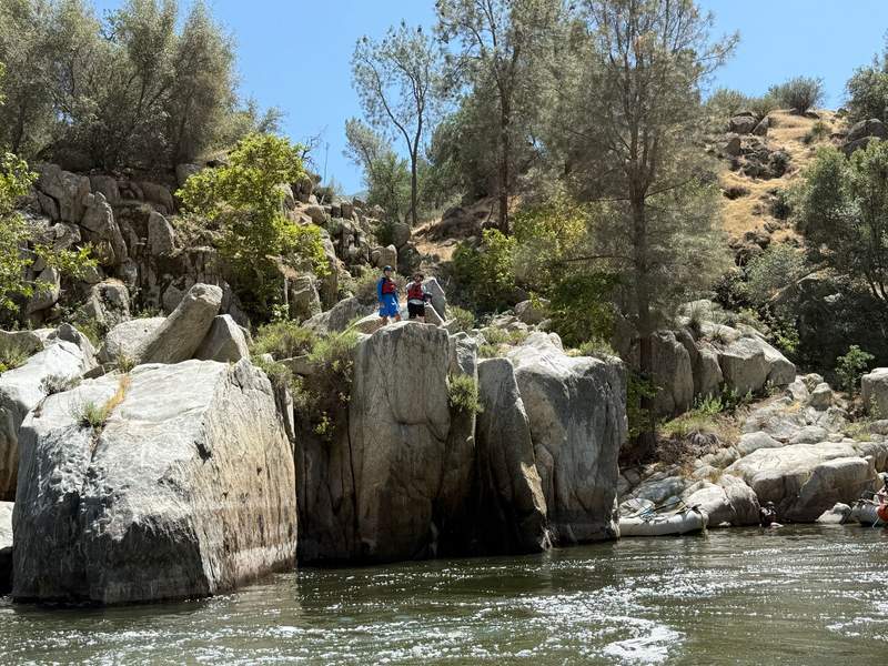 Guys standing on a rock outcropping overlooking the Kern River.