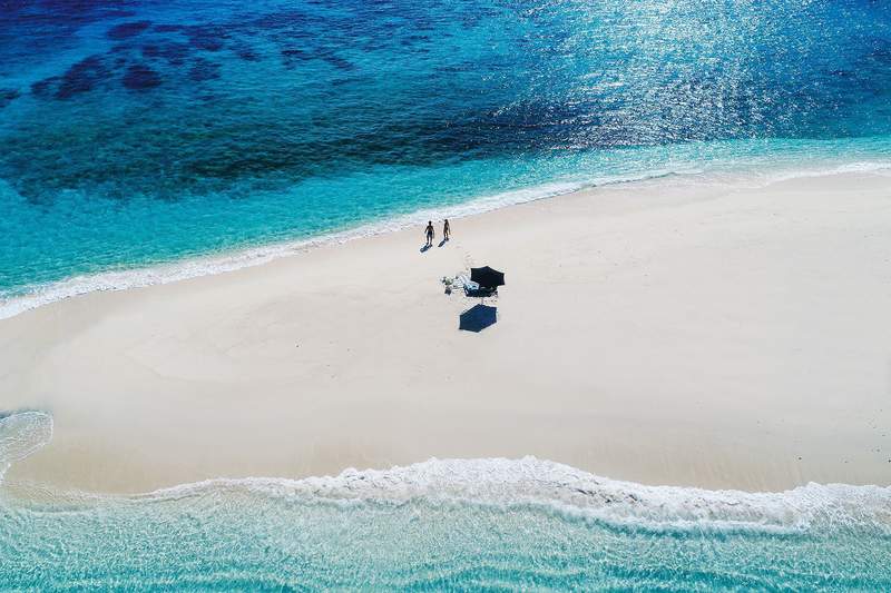 couple on private beach in Fiji with white sand and blue water